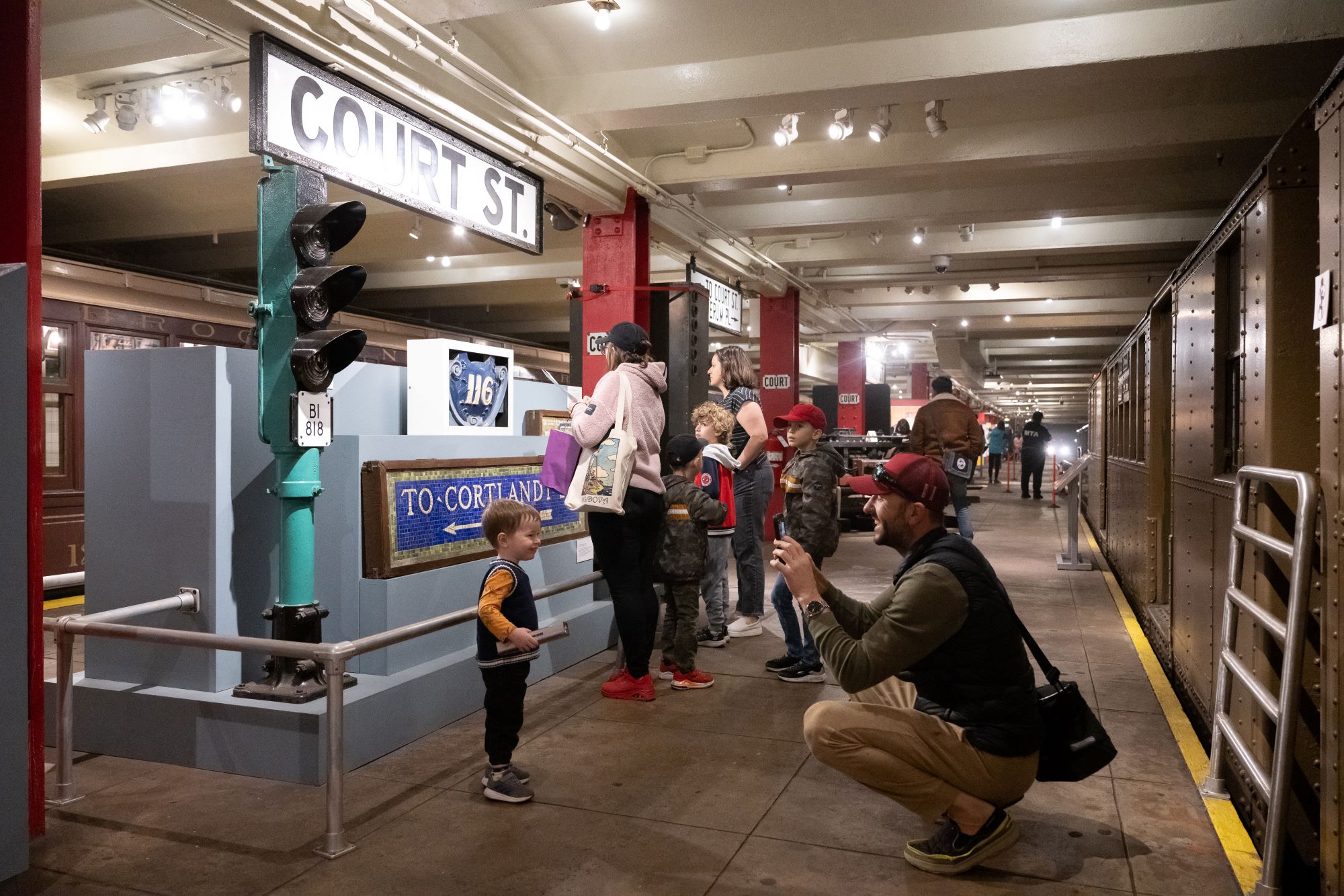 Parent taking photo of child on Transit Museum Platform