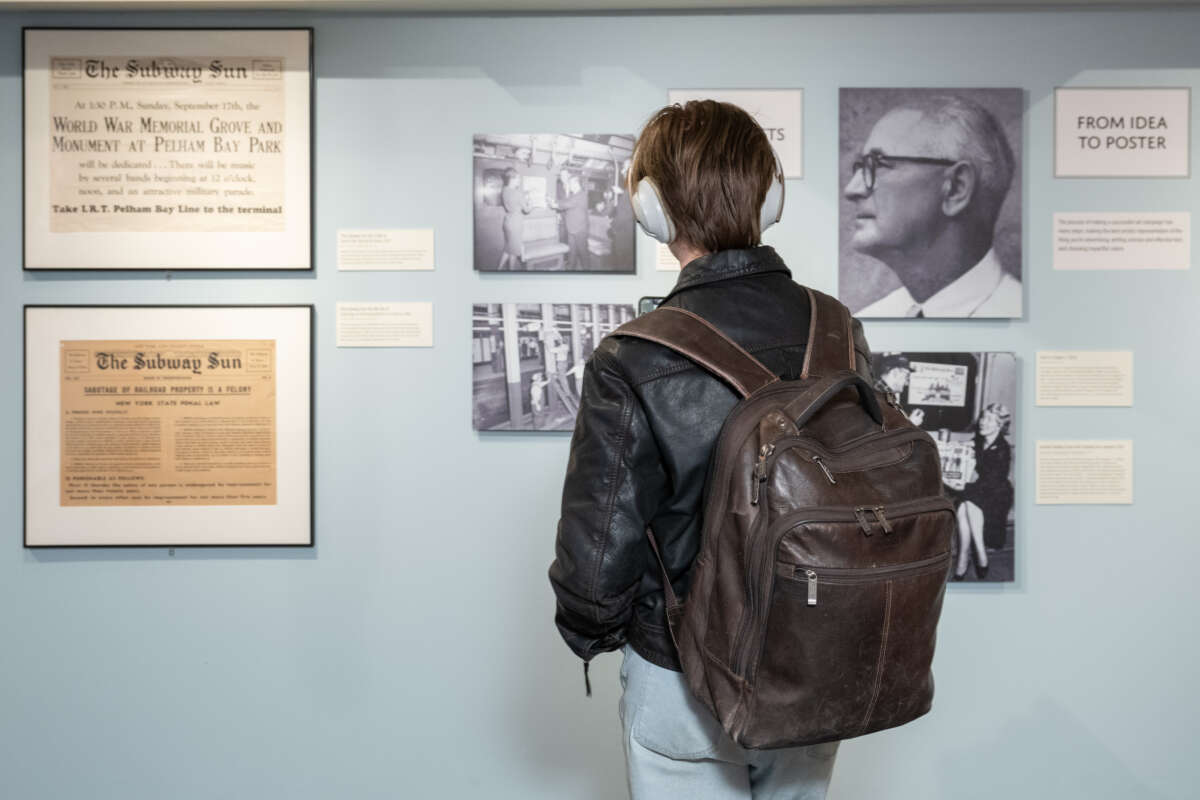 Person in front of images from Shining a light on The Subway Sun exhibit